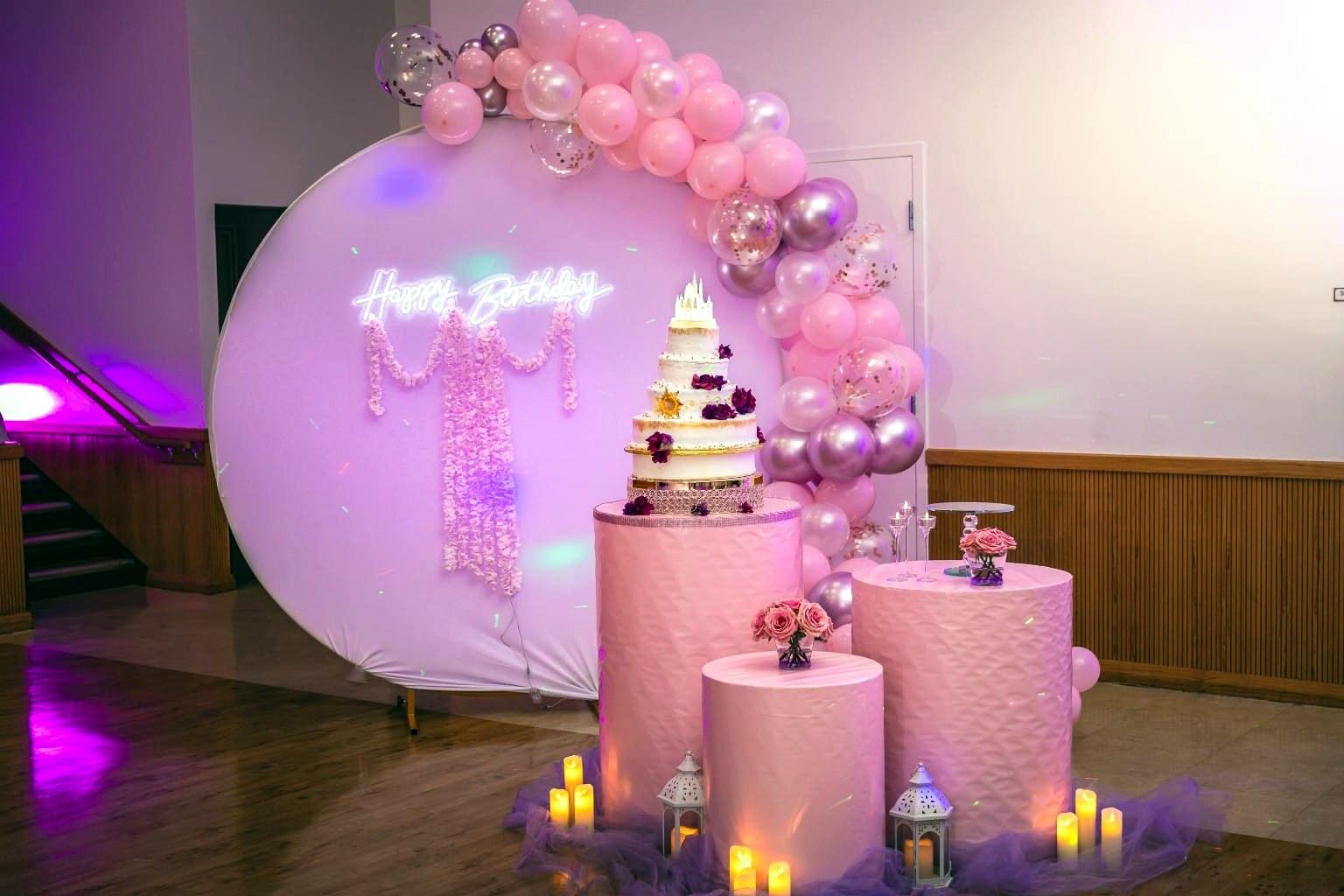 Mesa de pastel de cumpleaños con letrero de neón y globos