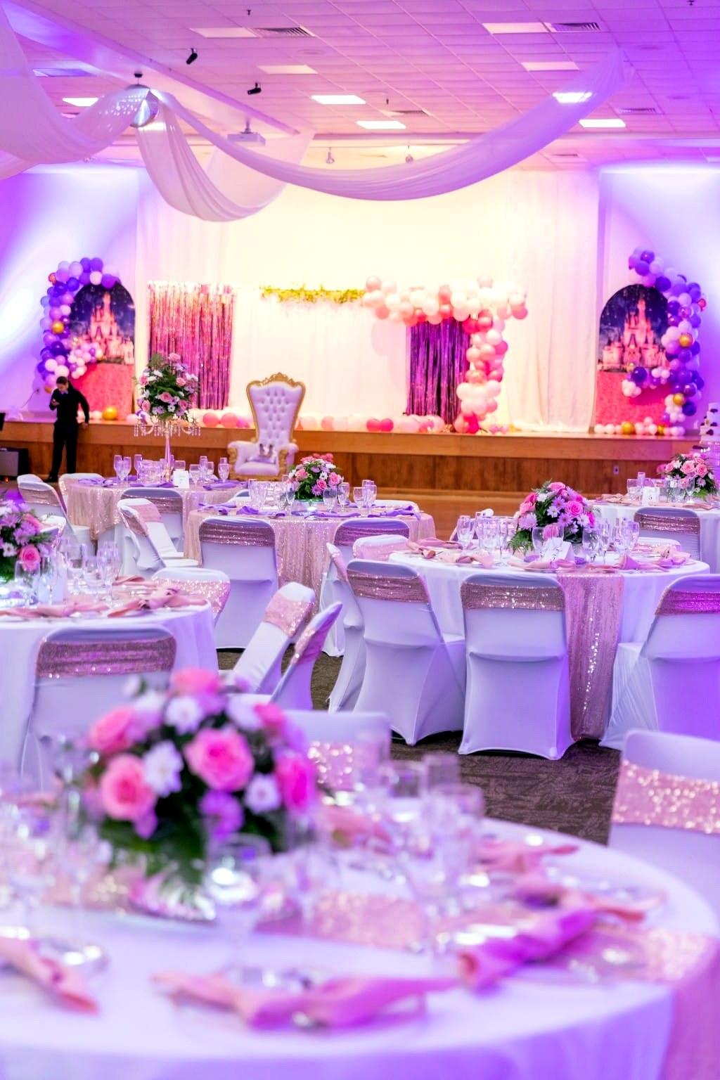 Escenario de quinceañera con arcos de globos y telón de castillo
